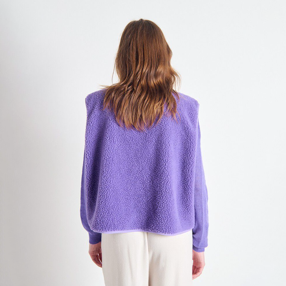 Person wearing a purple textured sweater on a white background
